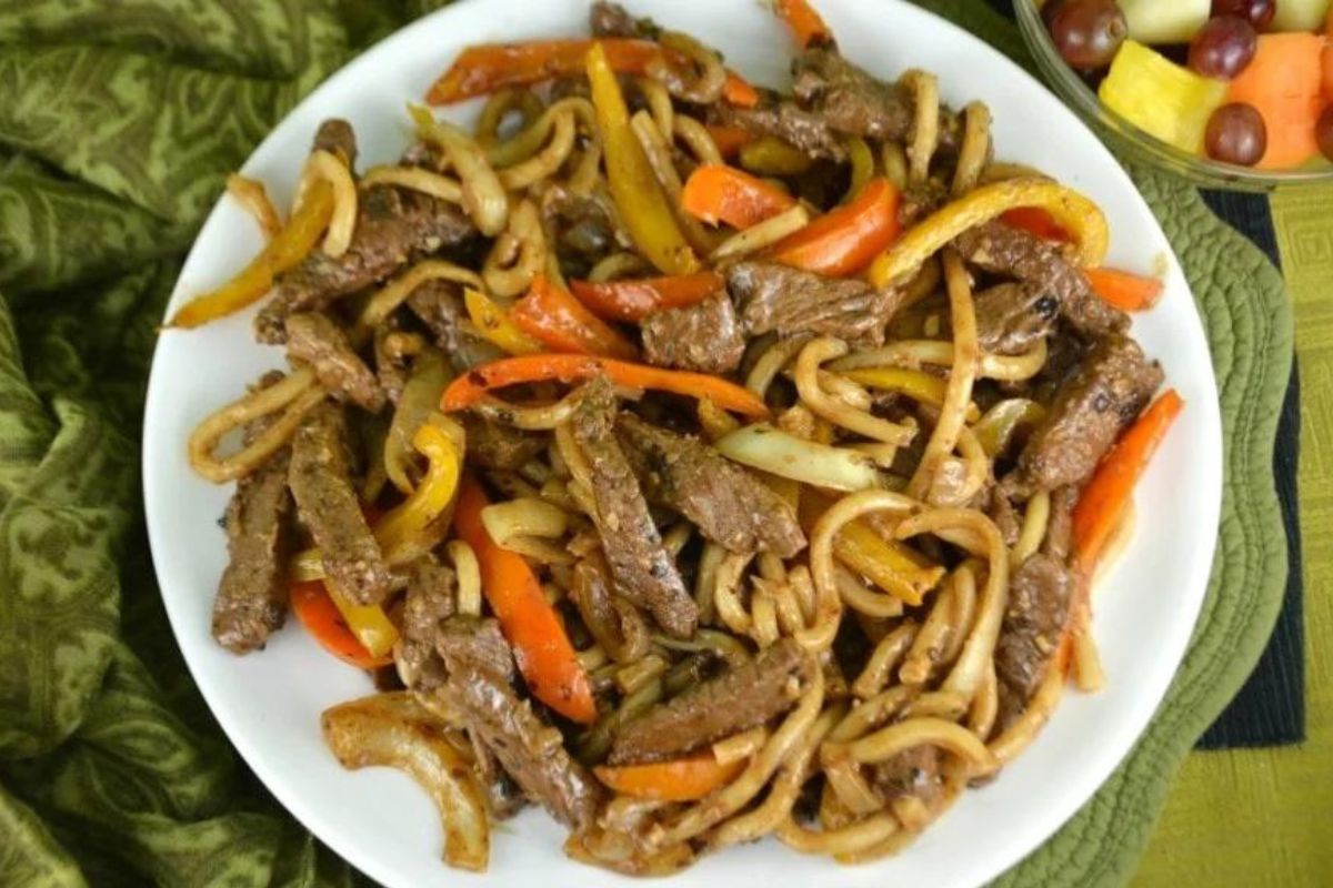 Stir-fried beef and noodles with mixed vegetables and recipes featuring noodles on a white plate.