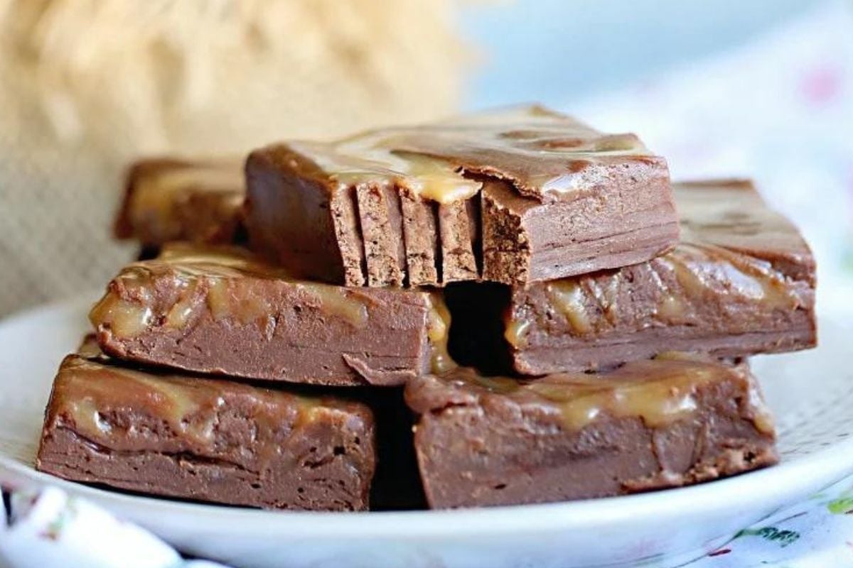 Stacked chocolate caramel fudge slices on a plate from our caramel recipes collection.