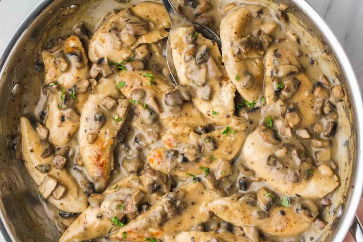Creamy chicken and mushroom skillet dish made with a can of cream soup, garnished with herbs, close-up view.