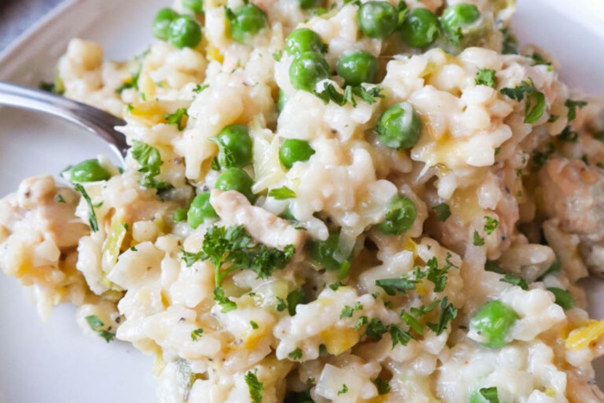 Creamy risotto with green peas and herbs, made using frozen vegetables, served on a plate with a fork.