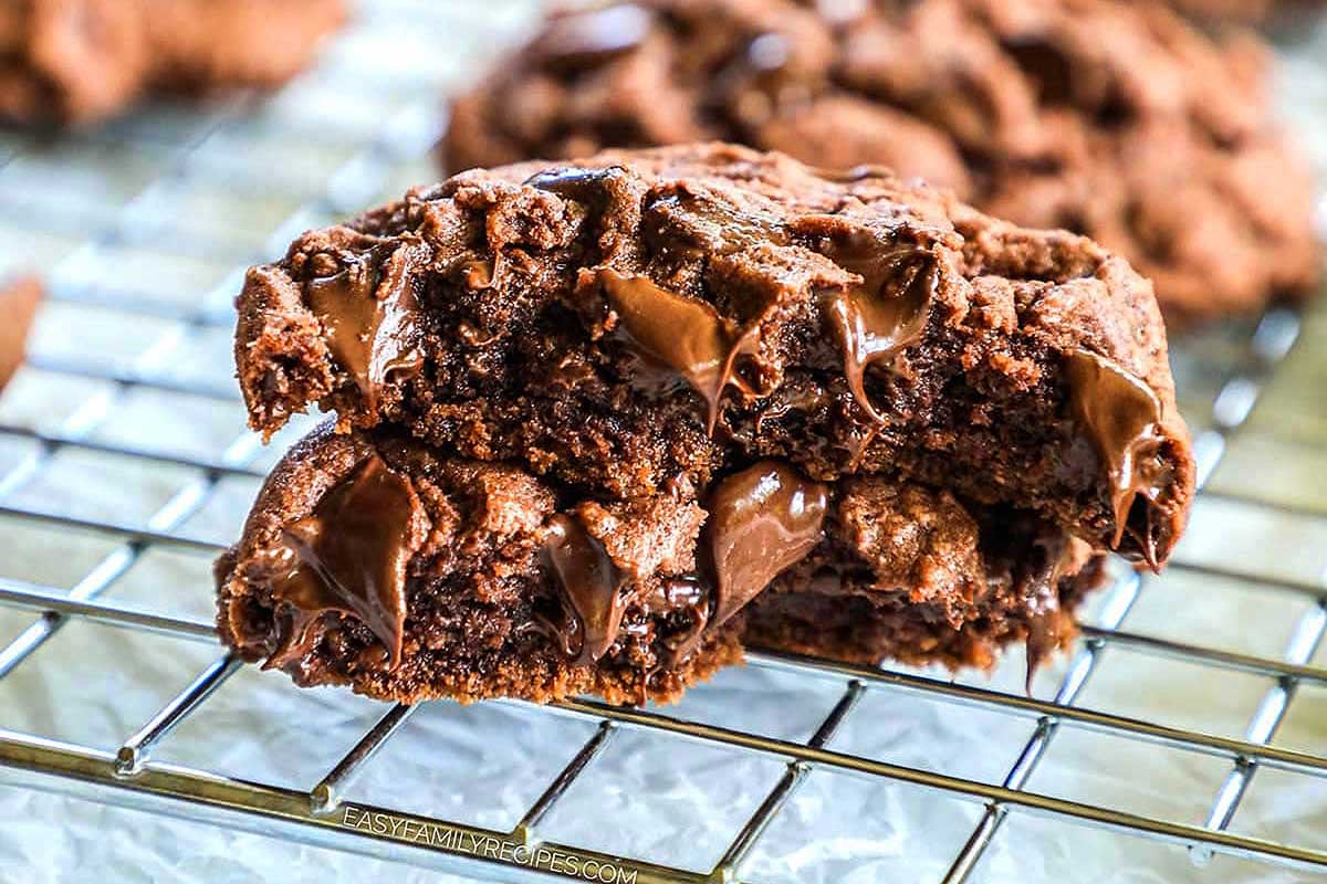 A gooey chocolate chip pudding mix cookie with a bite taken out, cooling on a wire rack.