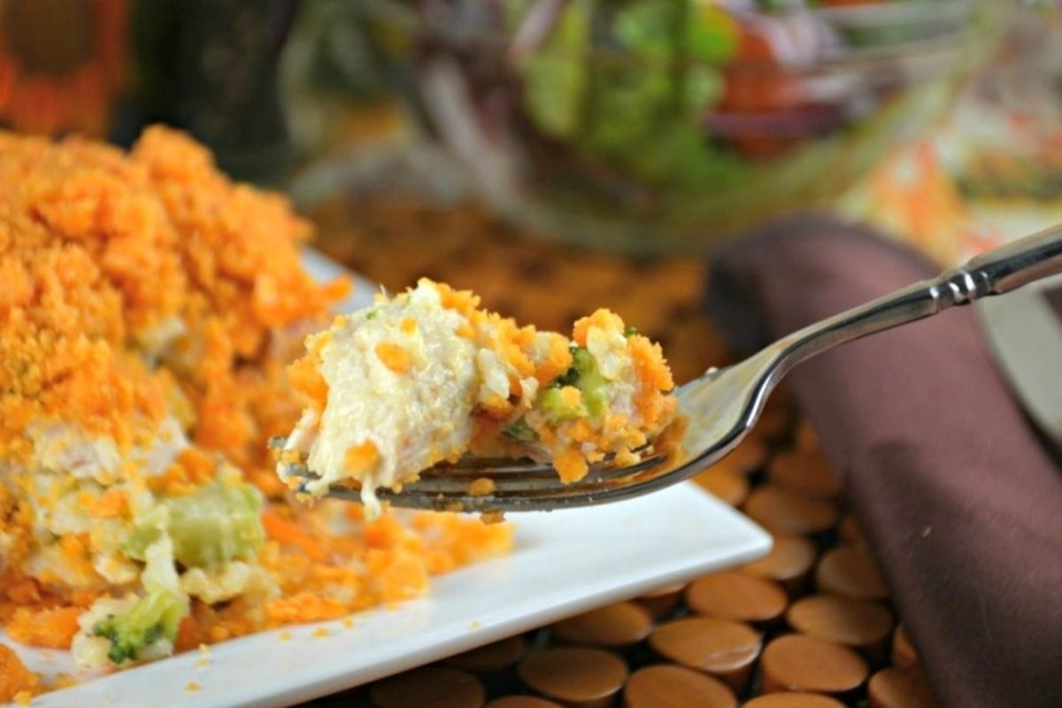 Close-up of a forkful of chicken shepherd's pie with a salad in the background.