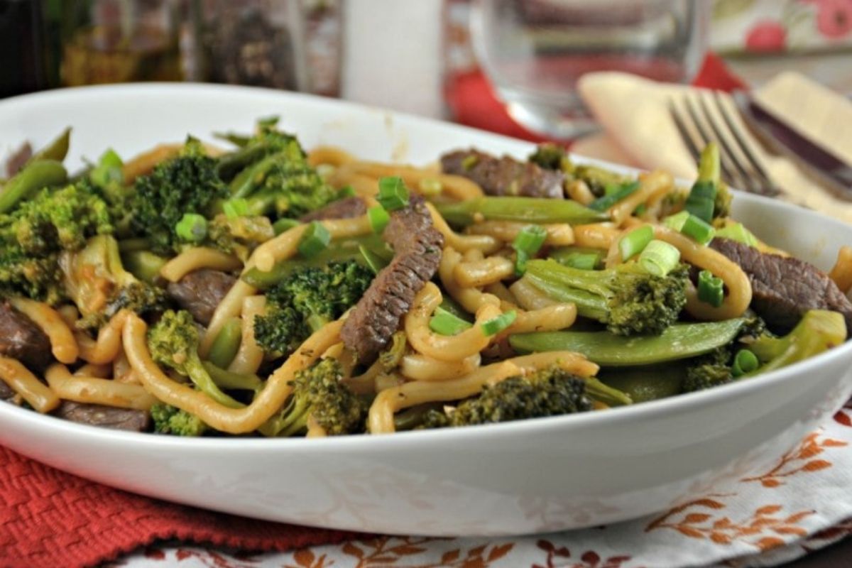 A plate of stir-fried noodles with beef and broccoli featuring recipes.
