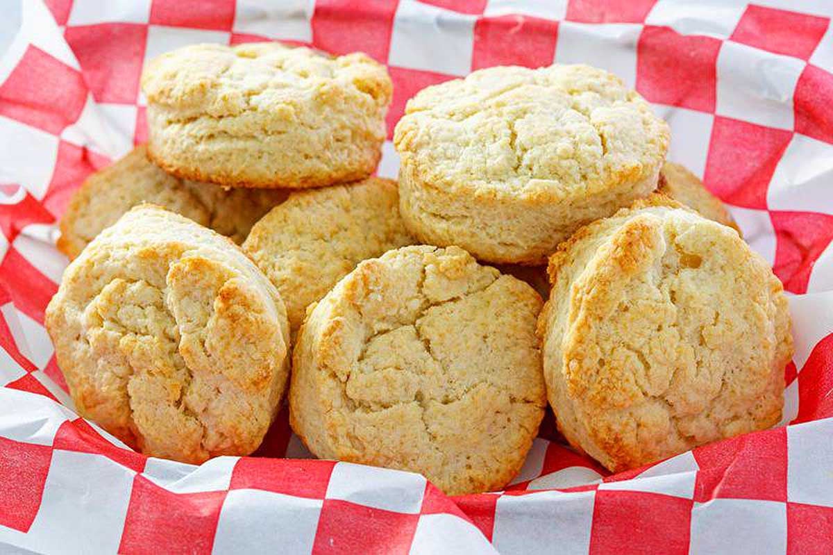 Freshly baked biscuits from KFC recipes, arranged on a red and white checkered paper.
