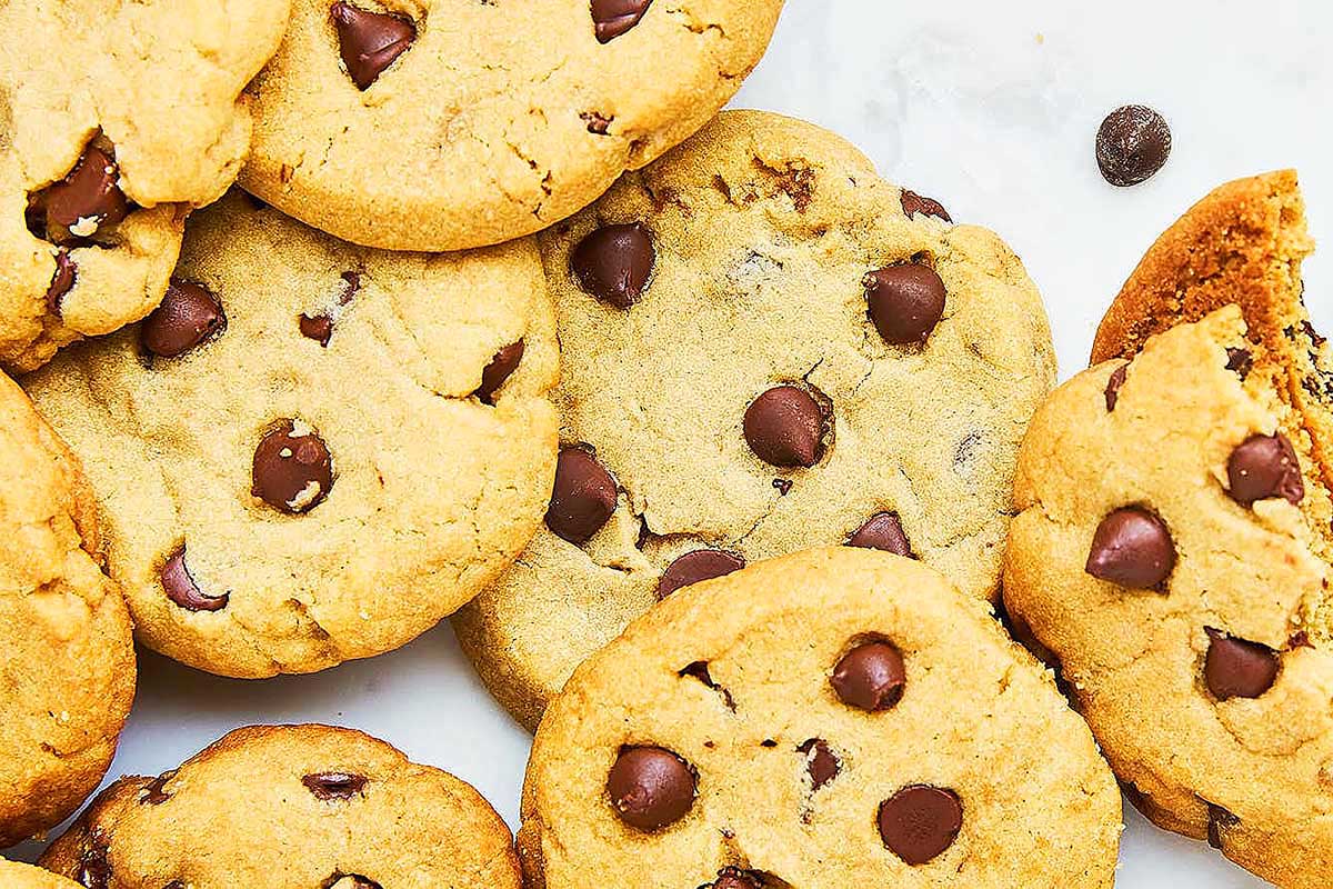 Freshly baked chocolate chip cookies with pudding mix on a white surface.