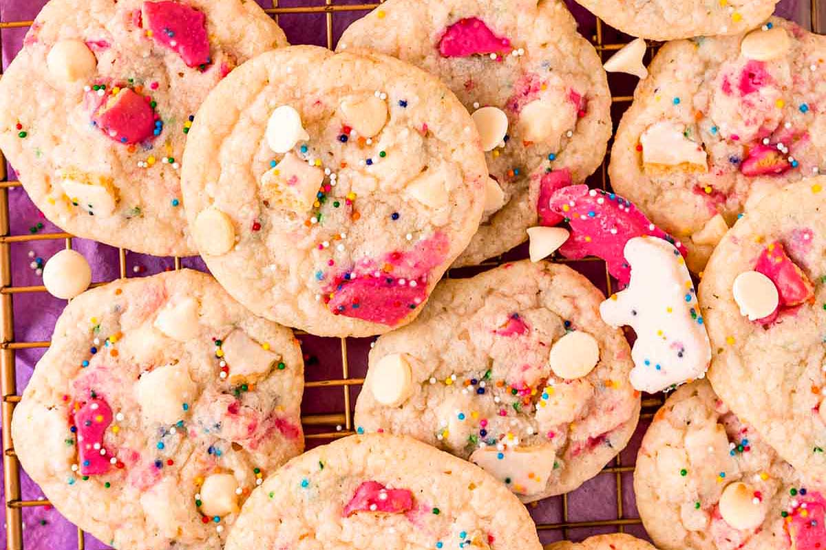 Homemade sugar cookies with white chocolate chips and colorful circus animal cookie sprinkles on a cooling rack.