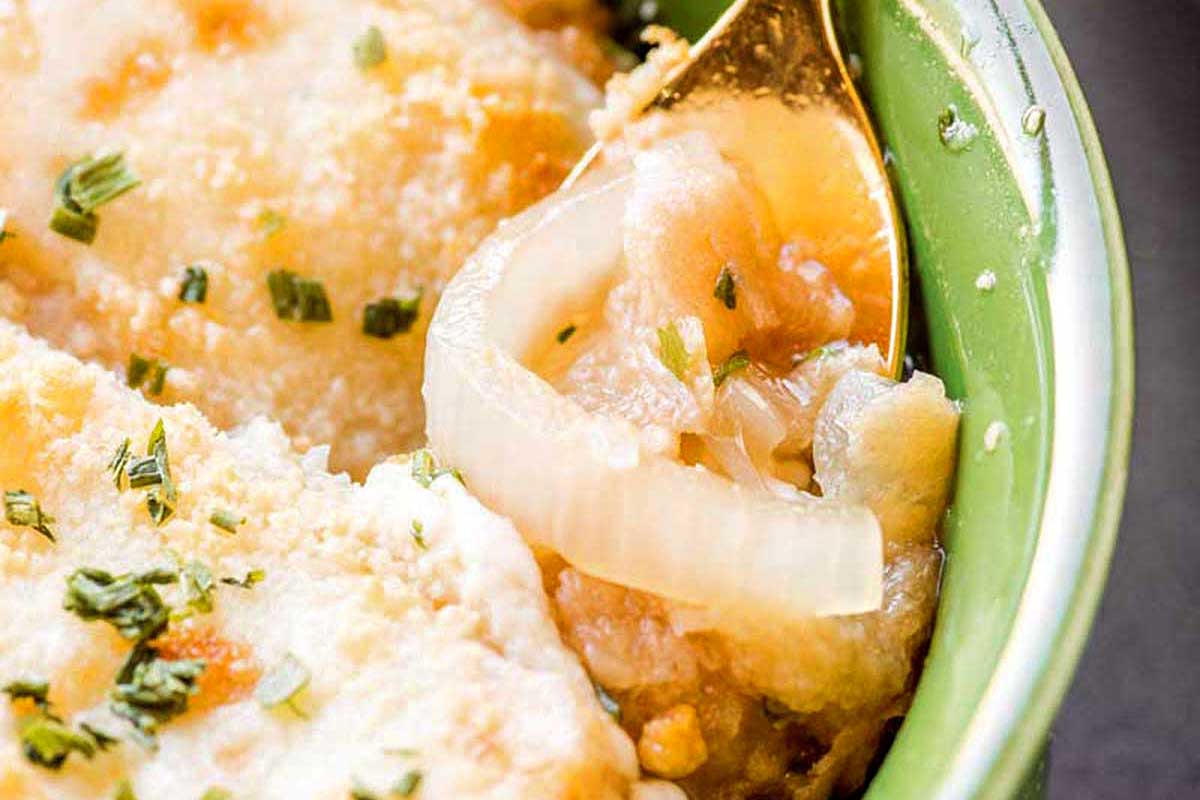 Close-up of a green bowl containing chicken marsala with mushrooms, garnished with chopped herbs and served in 30 minutes or less.