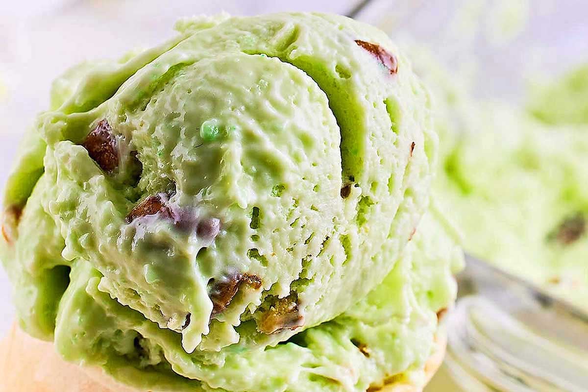 Scoop of pistachio pudding mix ice cream with visible nut chunks.