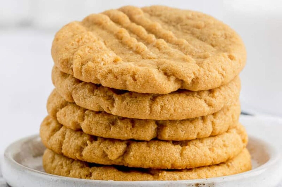 A stack of five peanut butter cookies on a white plate, perfect for those who love shortcut desserts.