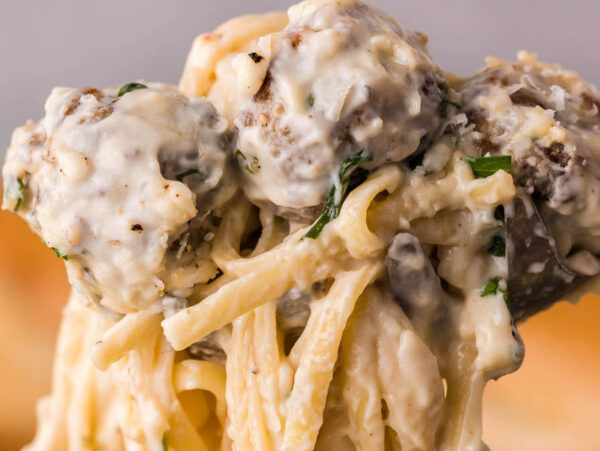 Meatballs and pasta held in the air.