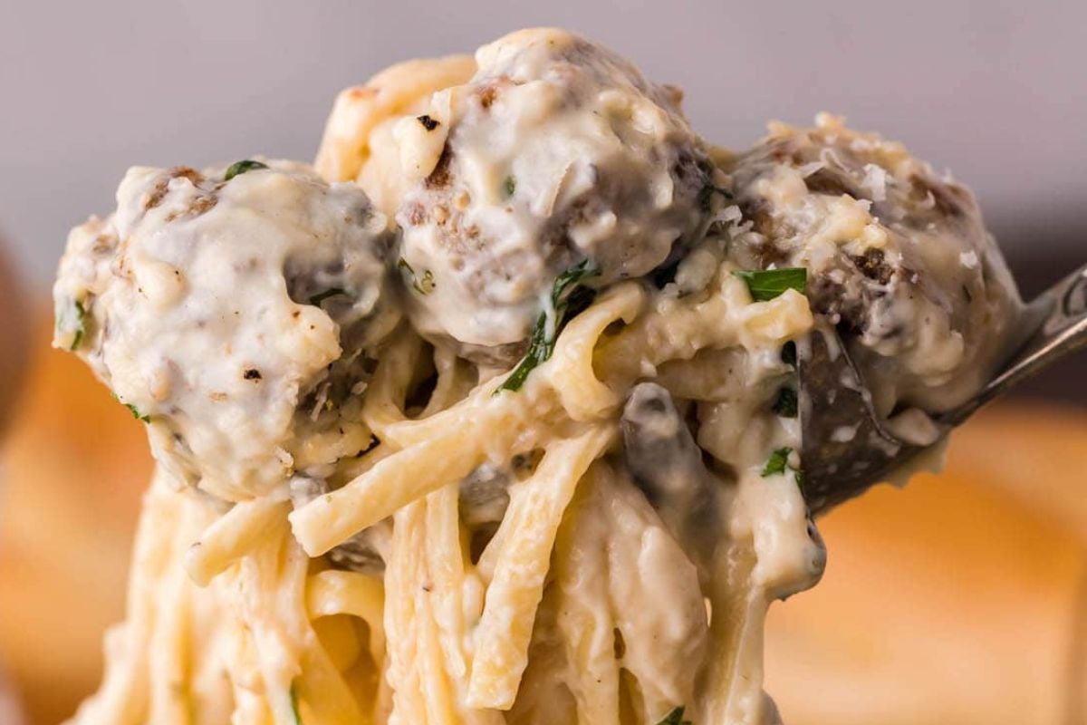 Meatballs and pasta held in the air.