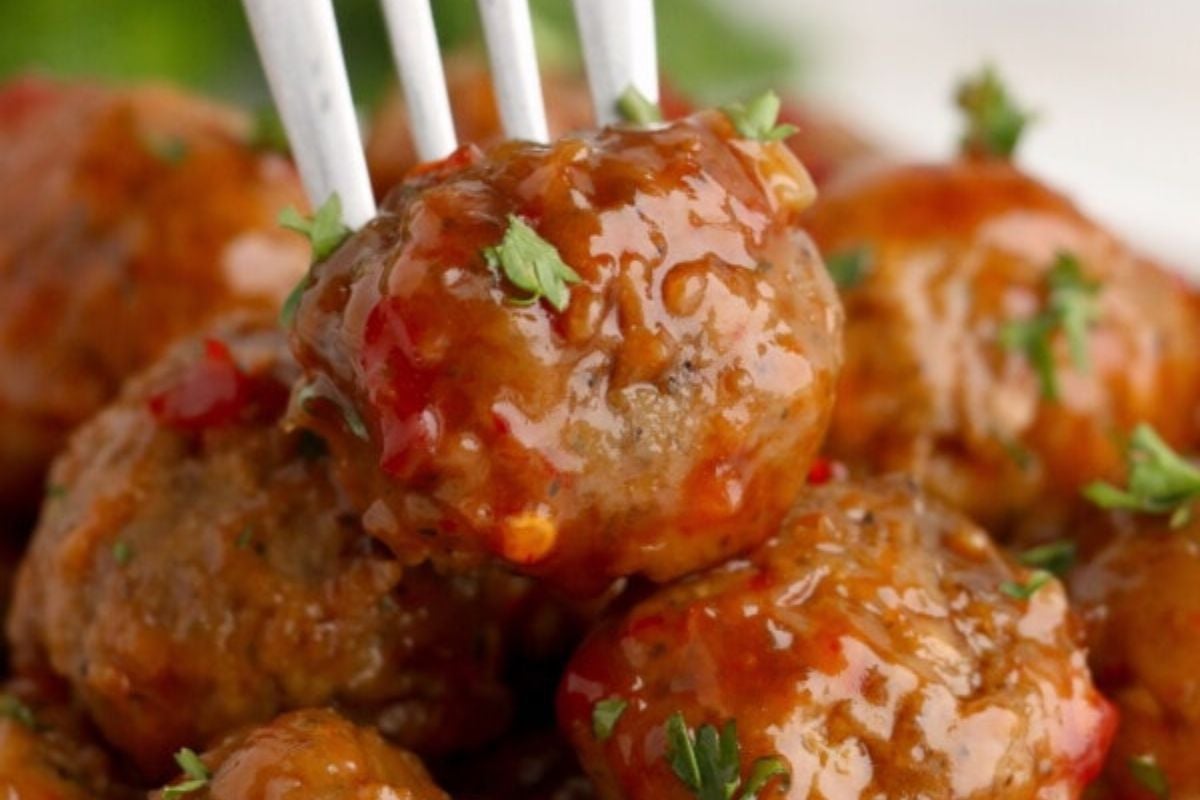 Sweet And Spicy Meatballs in a pile with one with a fork.