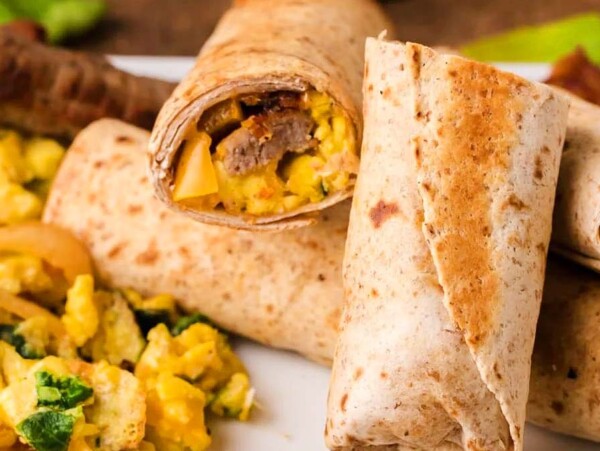 Three breakfast burritos on a plate, packed with eggs and vegetables, make for one of the most delicious and easy egg recipes.