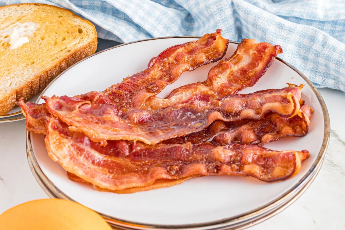 Slices of Cooked toaster oven bacon on a plate.