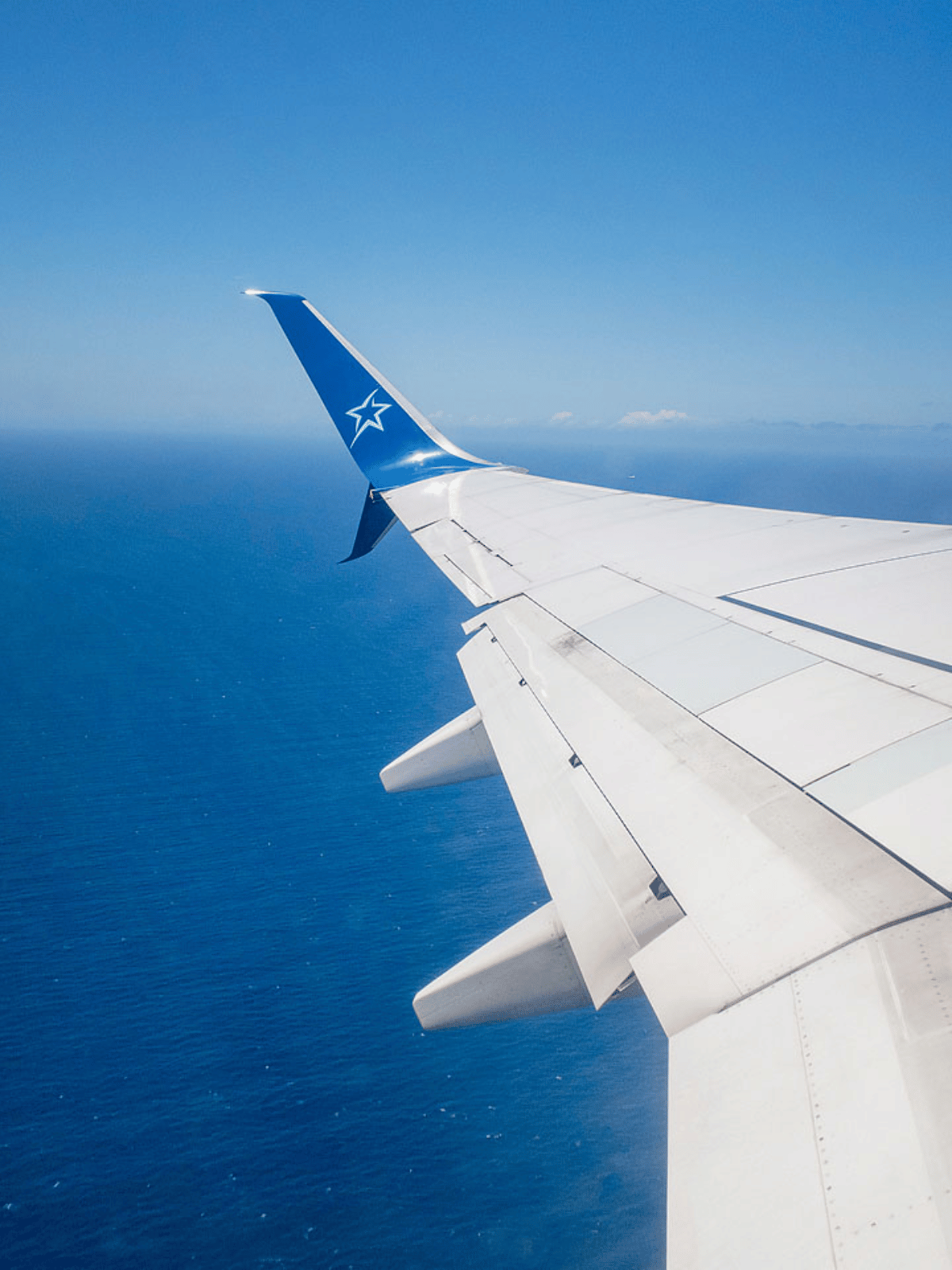 Wing of Air Transat over the ocean. 