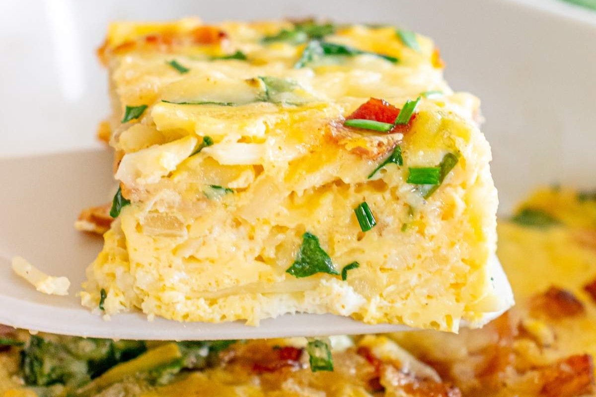 A slice of hash brown breakfast casserole on a white spatula.