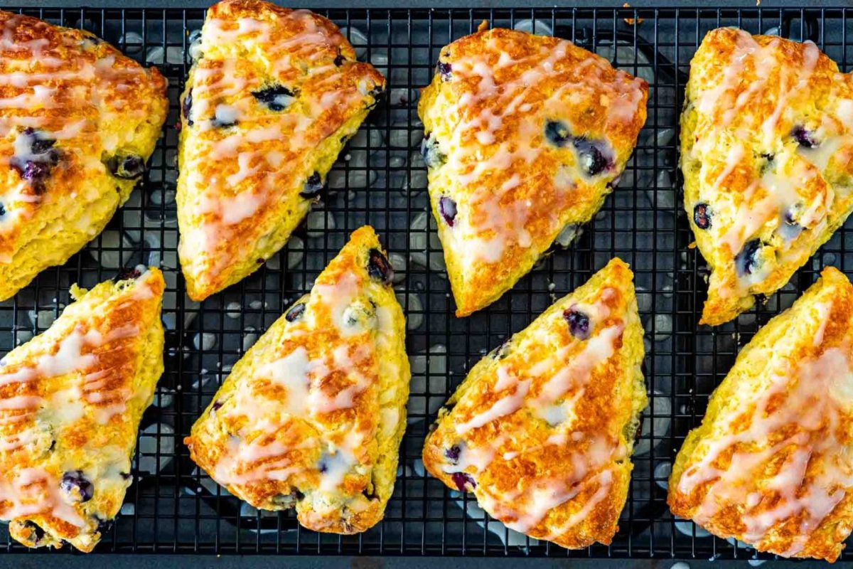 Eight glazed blueberry scones arranged on a cooling rack, a delicious addition to your favorite blueberry recipes.