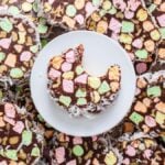 A plate of classic church window cookies, with one piece partially eaten, surrounded by more slices and scattered marshmallows.