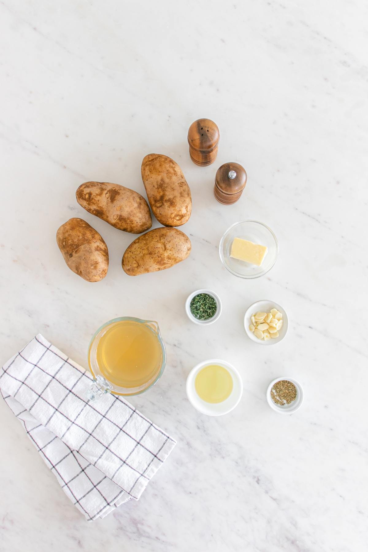 Four potatoes, butter, sliced garlic, spices, herbs, oil, broth, salt and pepper.
