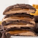 A tempting stack of chocolate-covered Milky Way bites, with scattered chocolate chips.