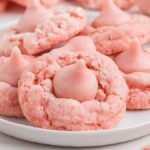 A plate of strawberry kiss cookies topped with delightful pink chocolate kisses.