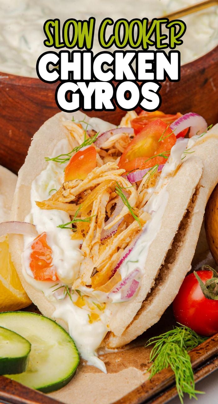 Pita filled with shredded chicken, tomatoes, onions, and homemade tzatziki sauce, labeled "Slow Cooker Chicken Gyros"—made easy with an easy crock pot chicken recipe.