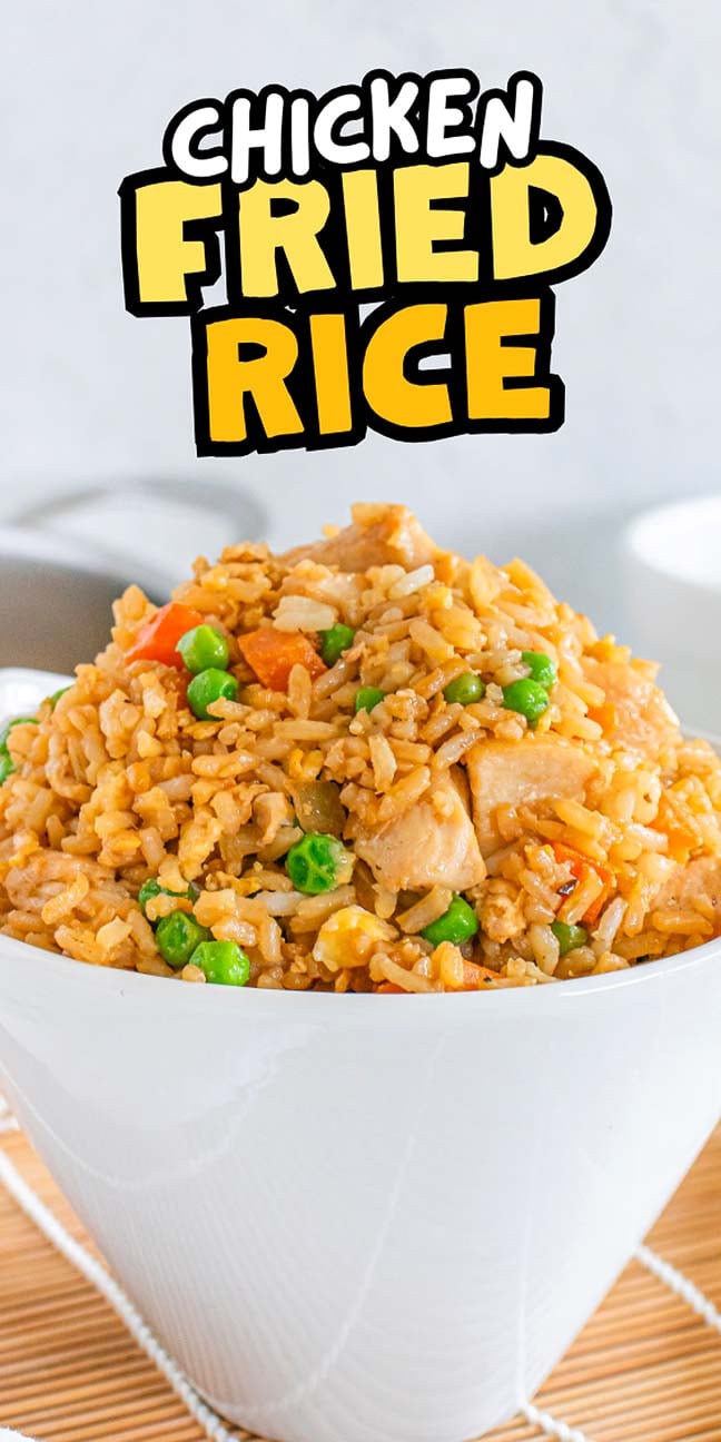 A delightful bowl of chicken fried rice overflowing with tender chicken, vibrant peas, carrots, and sweet corn.