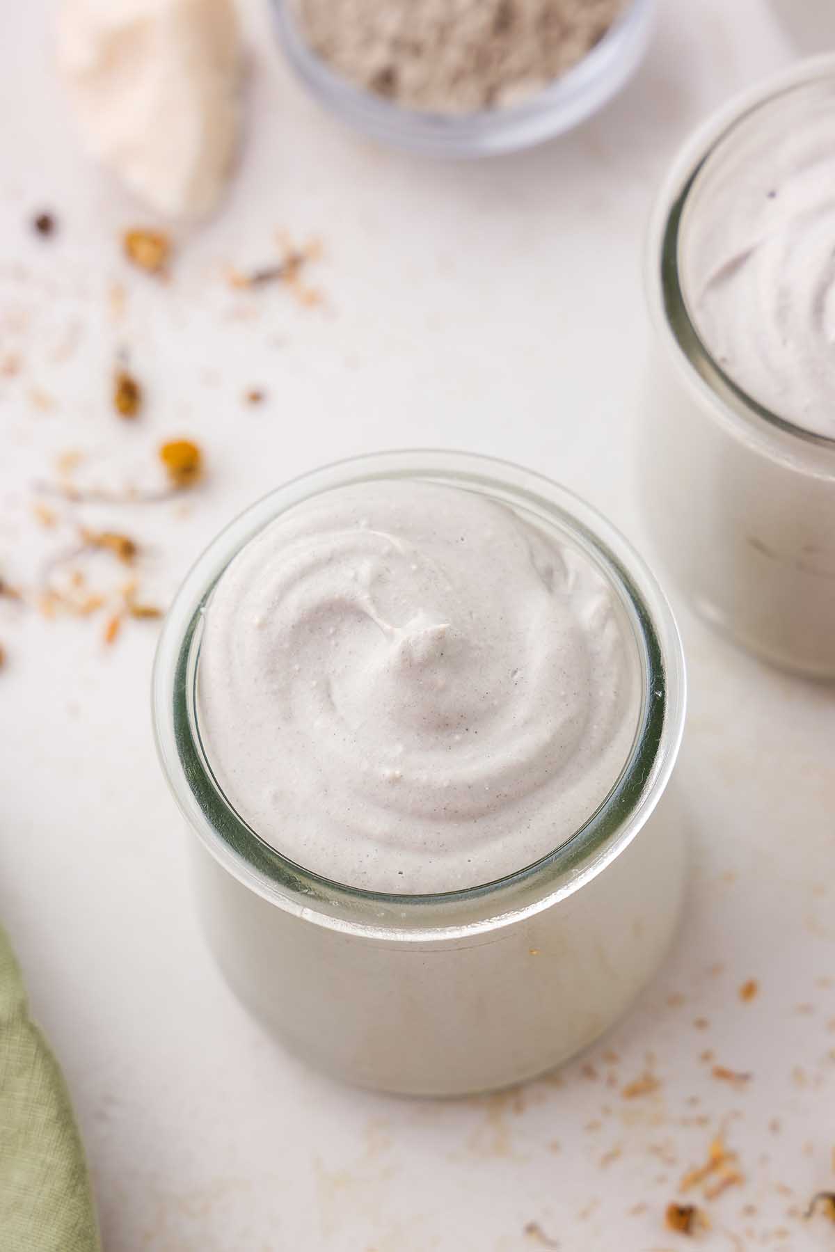 A jar of homemade diaper cream on a white surface.