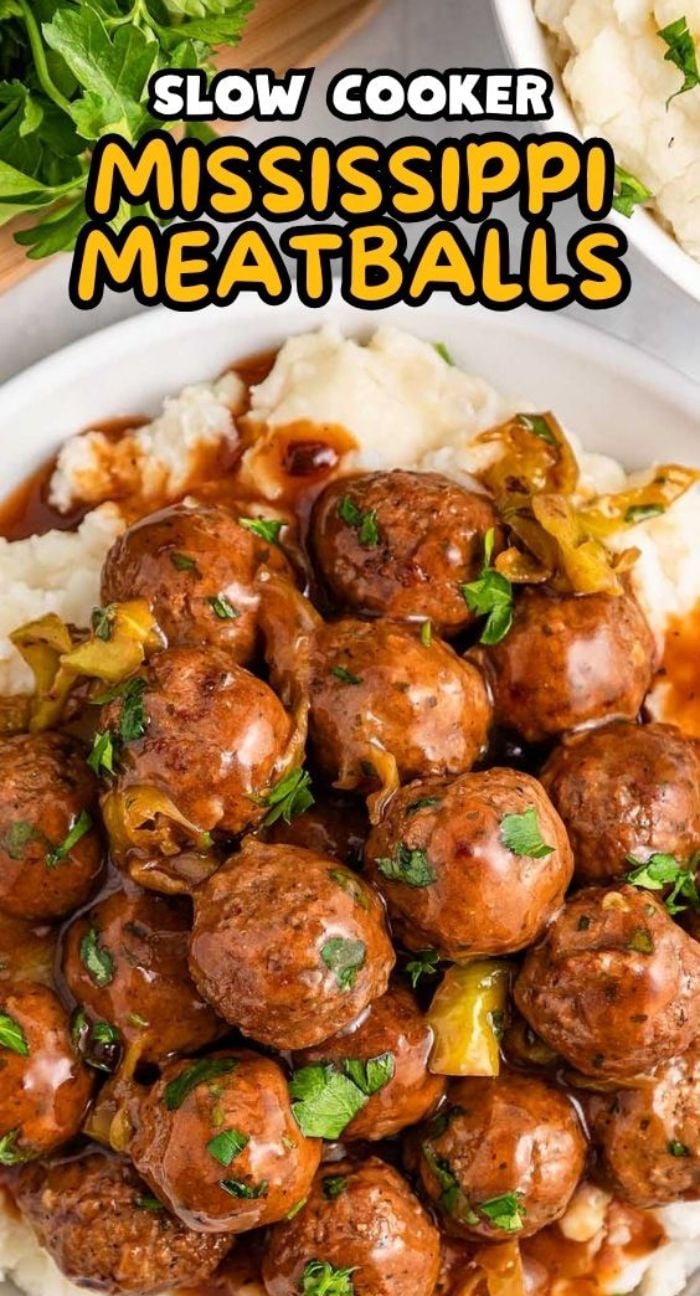 A plate of slow cooker Mississippi meatballs with savory sauce and parsley, served on creamy mashed potatoes.