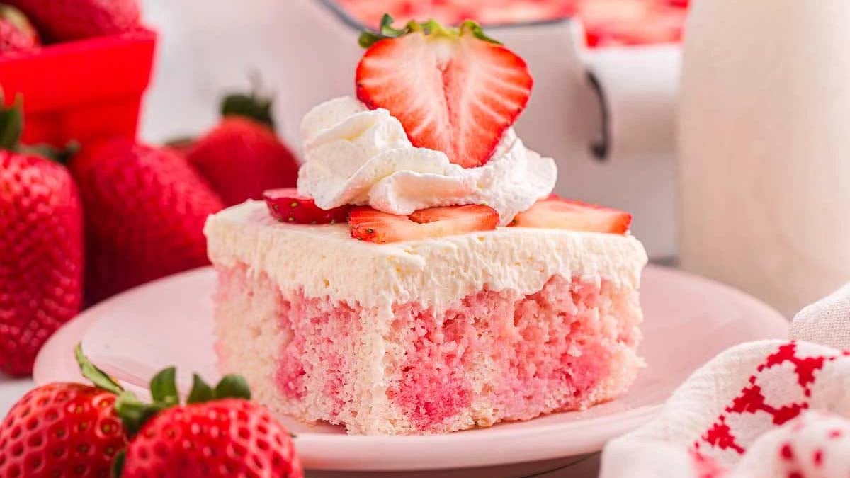 A slice of homemade poke cake with strawberries.