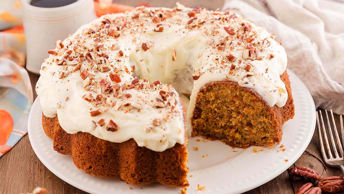 A plate with a carrot bundt take with a slice removed.