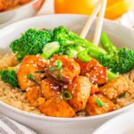 A bowl of brown rice topped with broccoli, and flavorful Orange Salmon Bites.