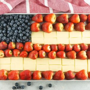 A Stars and Stripes Cheese Board features a tray arranged like the American flag, with blueberries, strawberries, and square pieces of cheese for a festive touch.