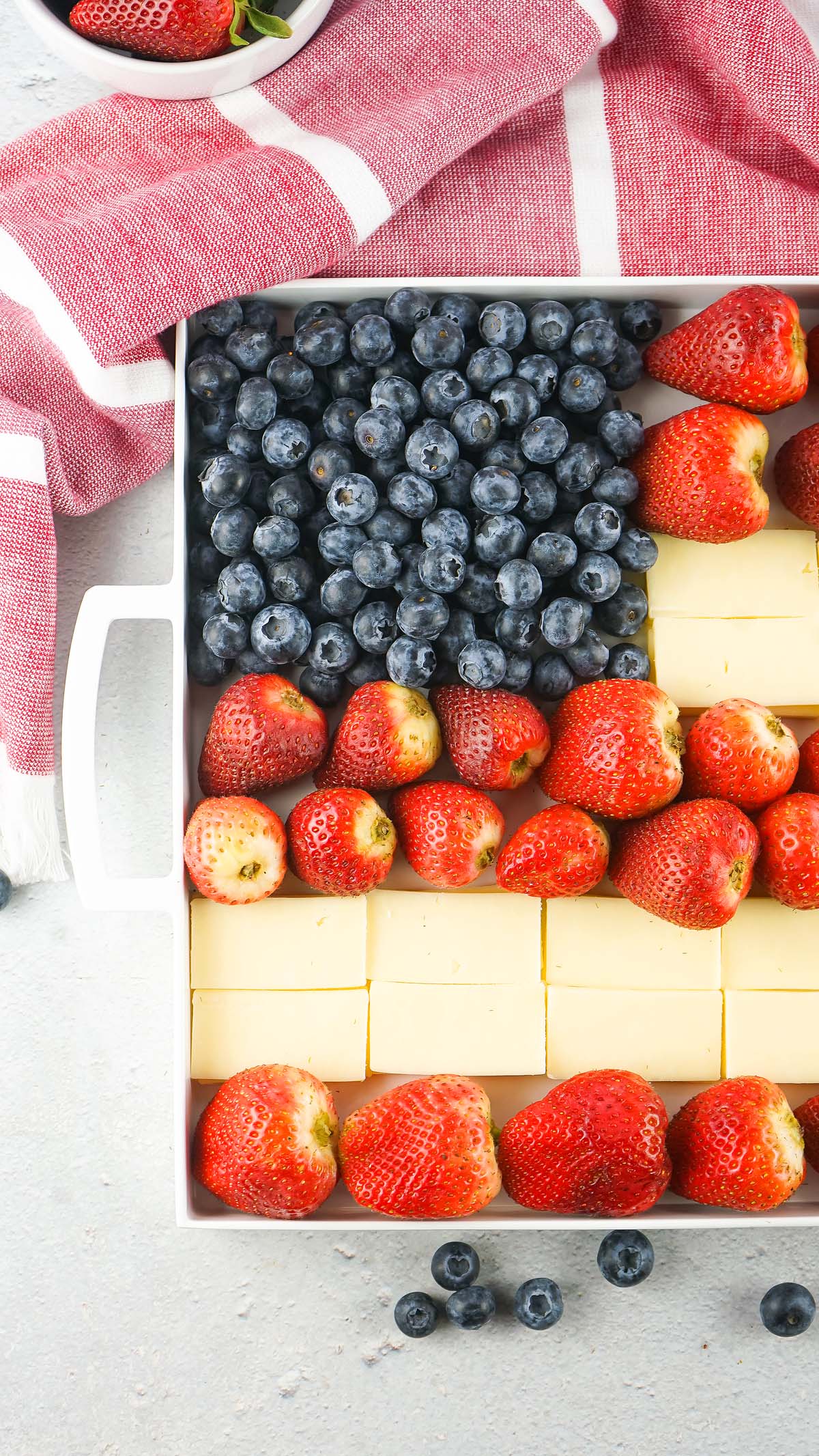 A Stars and Stripes Cheese Board features rows of strawberries, blueberries, and cheese artfully arranged to resemble the American flag.