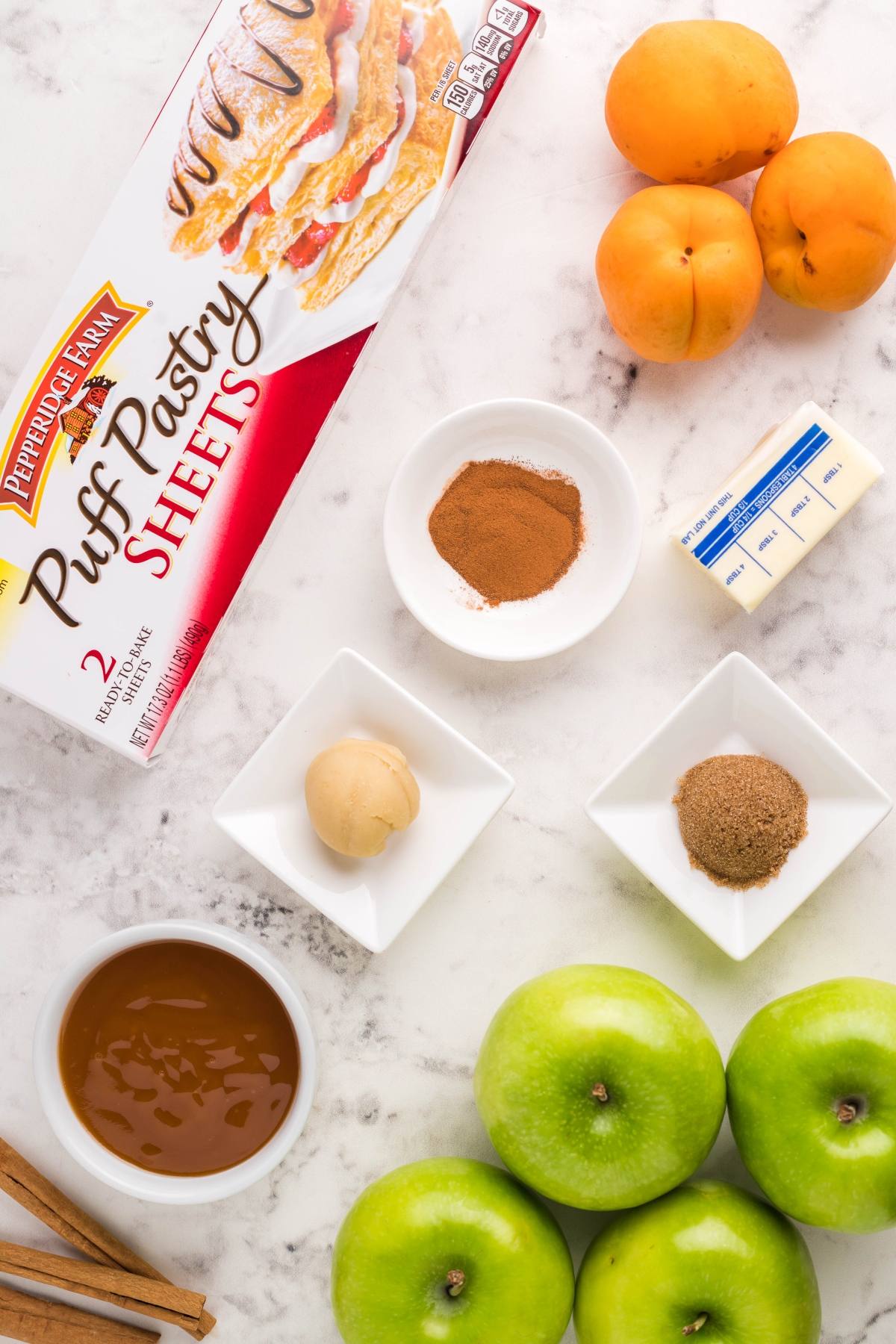 Ingredients for baking: puff pastry, apples, butter, apricots, spices, caramel, cinnamon, and brown sugar—perfect for making delicious Air Fryer Apricot Apple Dumplings or learning how to make dumplings with puff pastry.