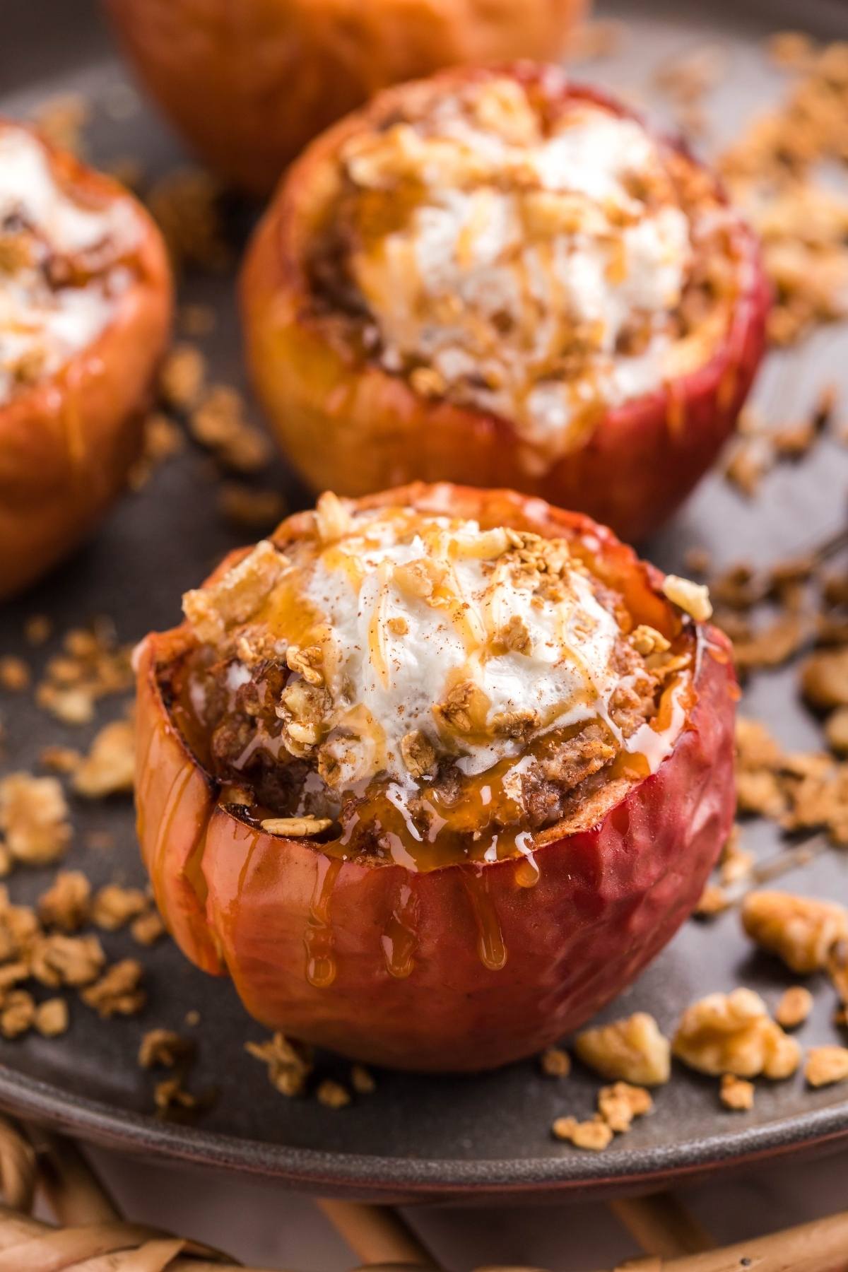 Baked apple filled with crumble, topped with vanilla ice cream and drizzled with maple syrup—an easy air fryer apple dessert served on a plate.