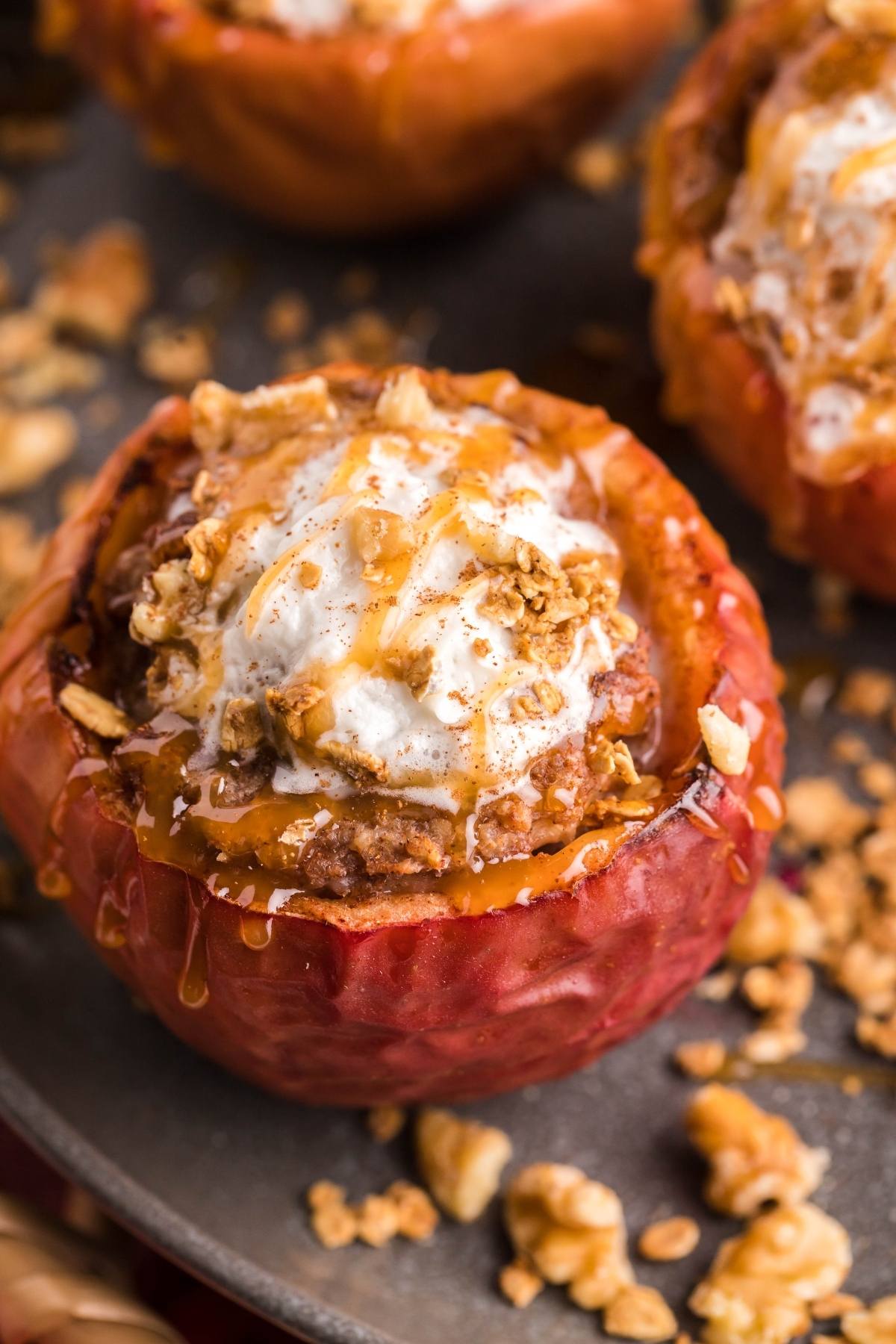 Baked apple filled with crumble, topped with ice cream, granola, and caramel drizzle—an easy air fryer apple dessert made with maple syrup for extra sweetness.