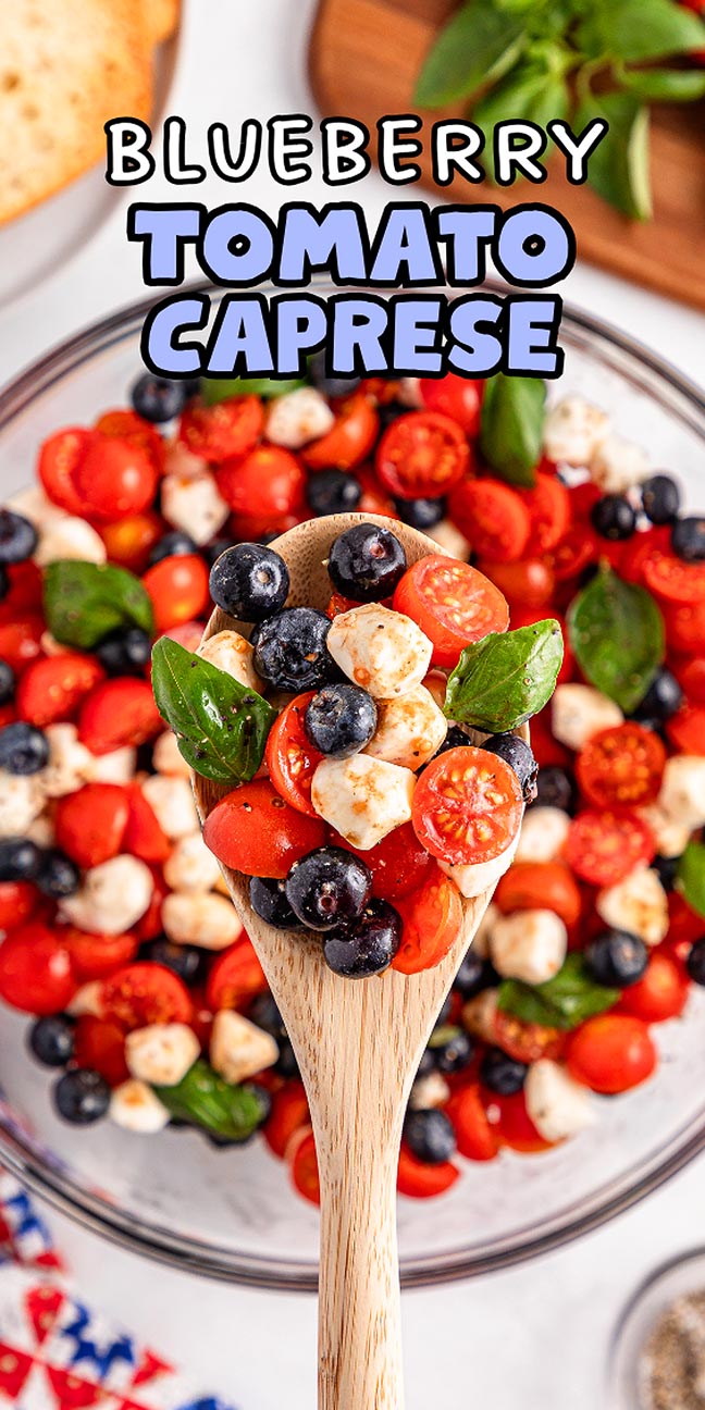 A wooden spoon holds blueberry tomato Caprese salad over a bowl, showcasing fresh basil and creamy mozzarella.