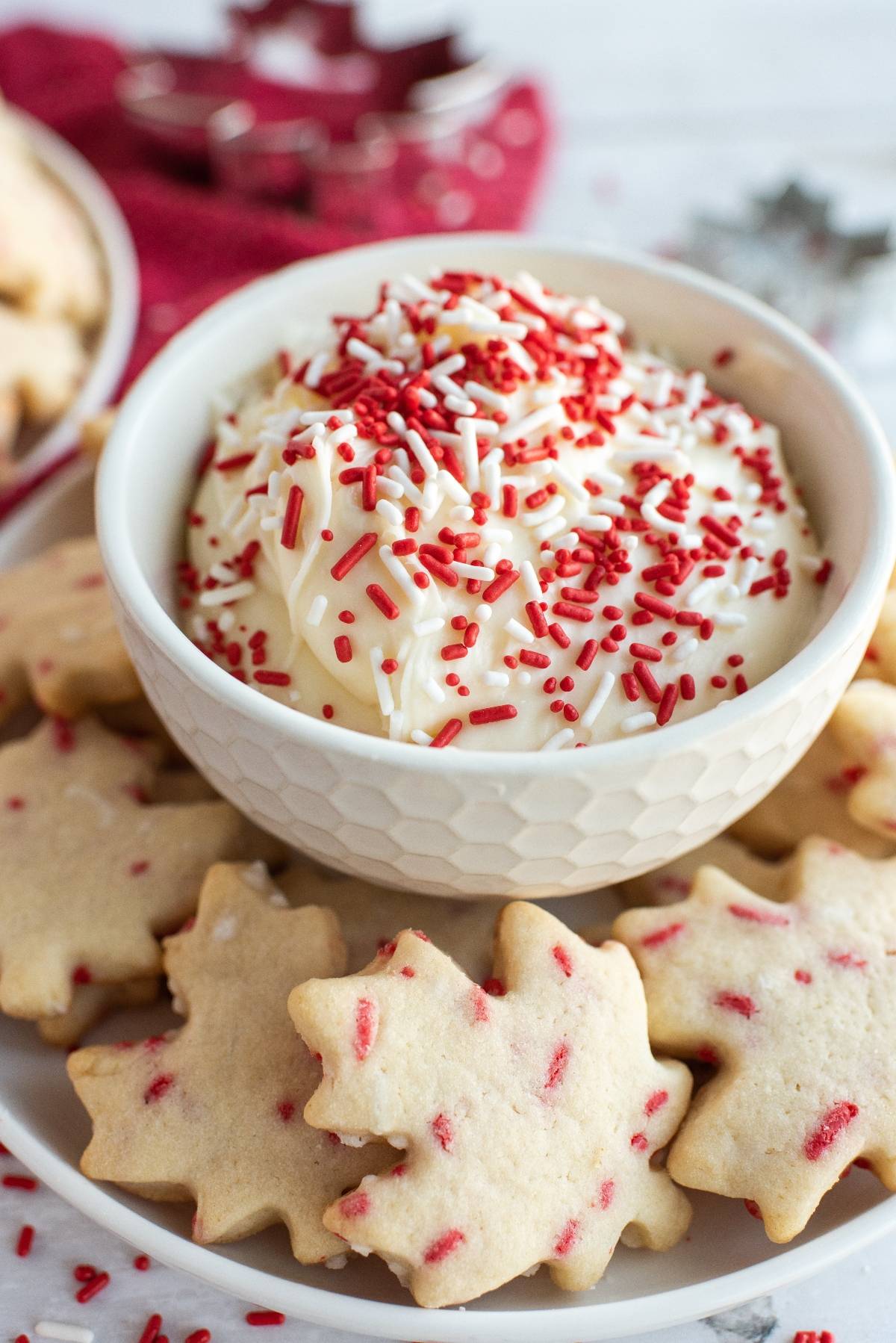 White bowl of creamy dip with red sprinkles, surrounded by maple leaf cookies—festive treats perfect for Canada Day dessert ideas.