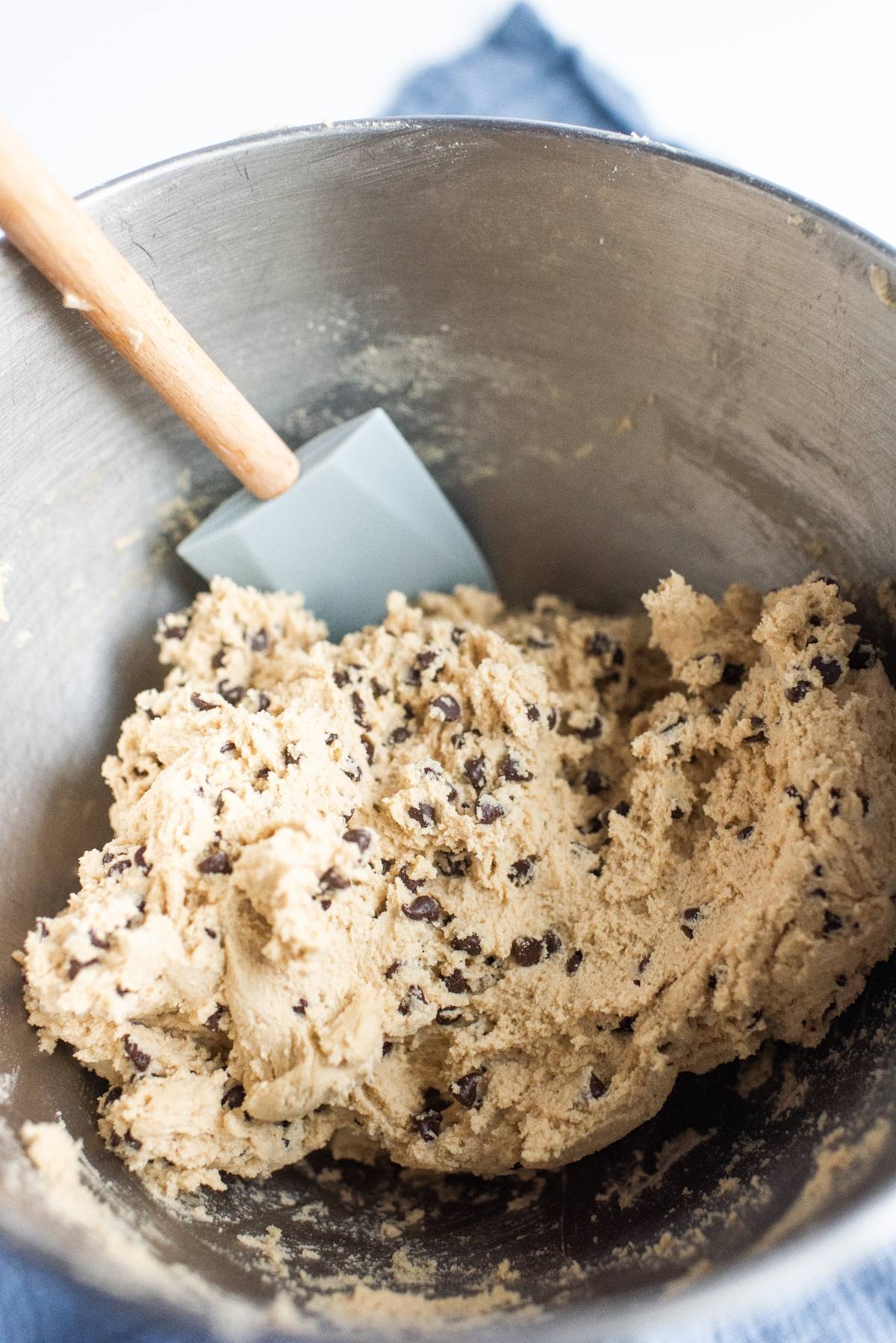Chocolate chip cookie dough in a metal mixing bowl with a spatula—ideal as the best filling for sandwich cookies or to pair with jam for the best sandwich cookies with jam.