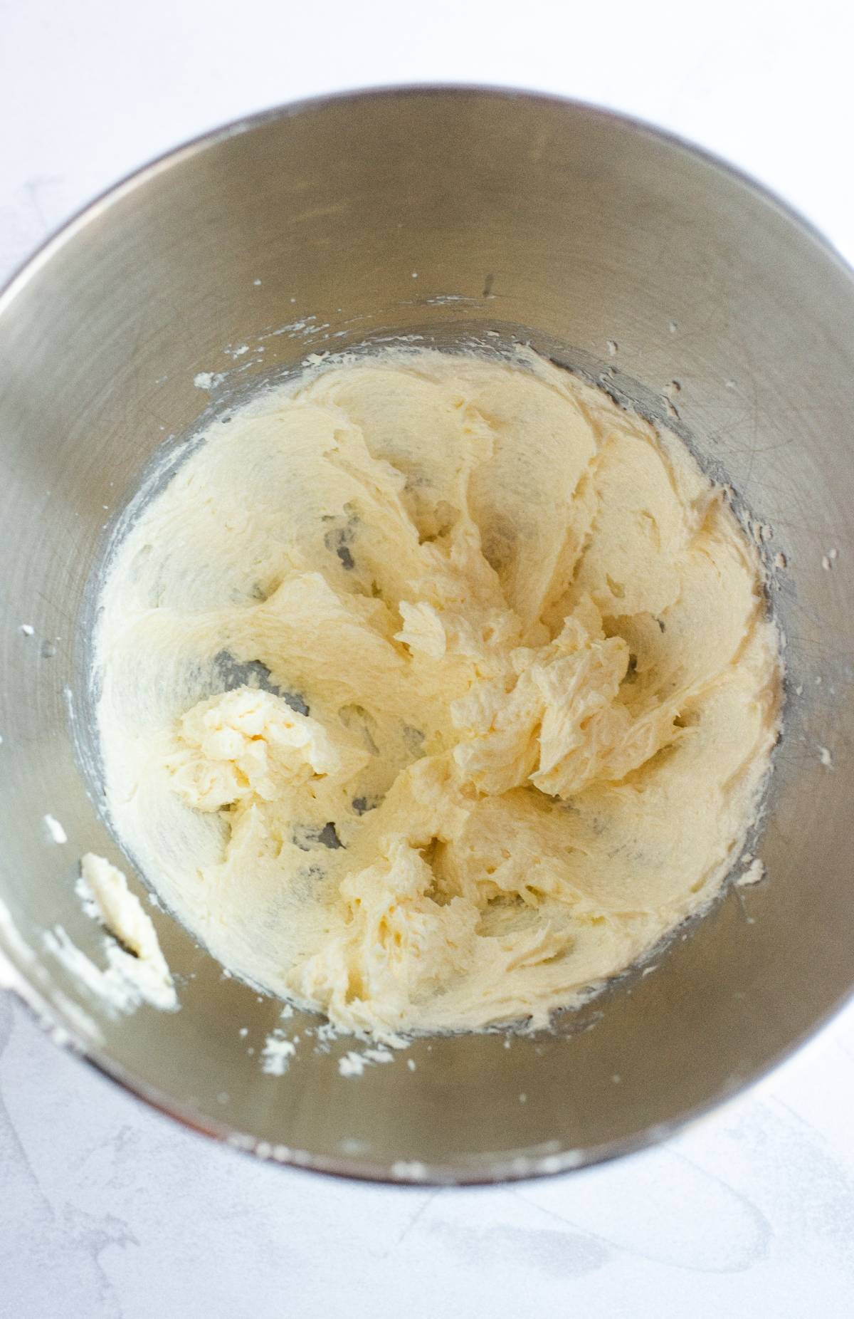 Creamed butter and sugar mixture in a metal mixing bowl, viewed from above—perfect as a base for Funfetti Dunkaroo dip or Disney Sugar Cookies with Dip.