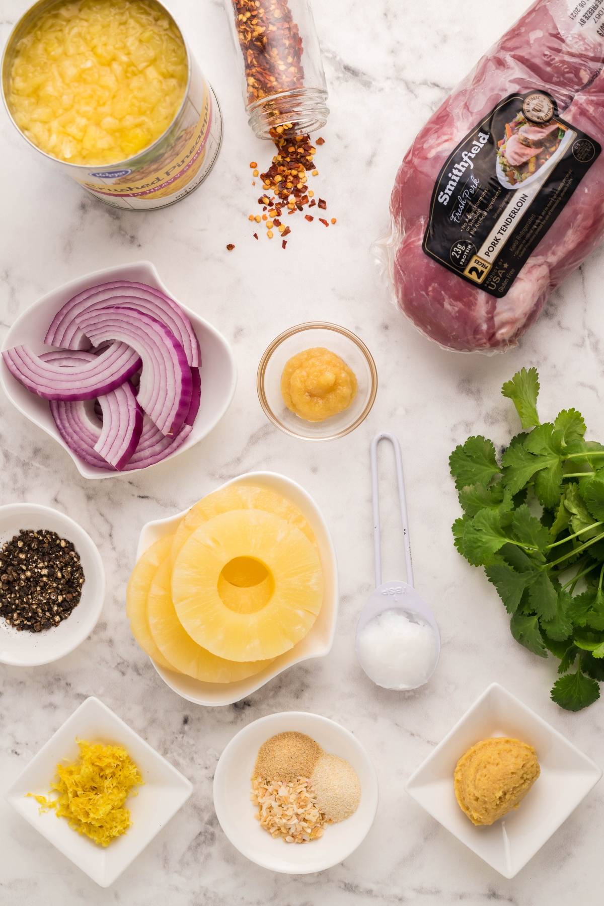 Ingredients for an easy Instant Pot pork tenderloin recipe, including pork tenderloin, pineapple, spices, onion, cilantro, and seasonings—perfect for a quick and flavorful Instant Pot dinner.