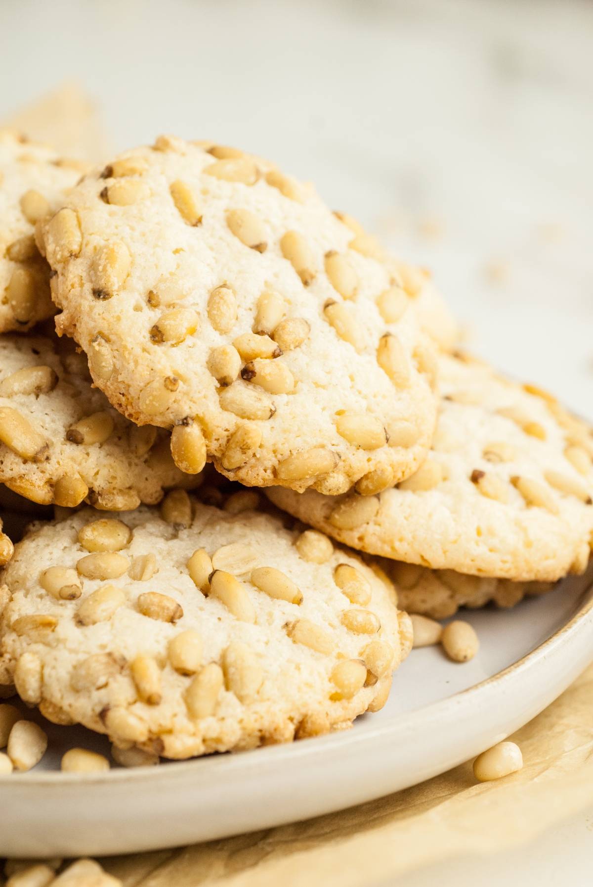 A plate of almond and pine nut cookies stacked on top of each other—perfect for easy gluten free holiday baking.