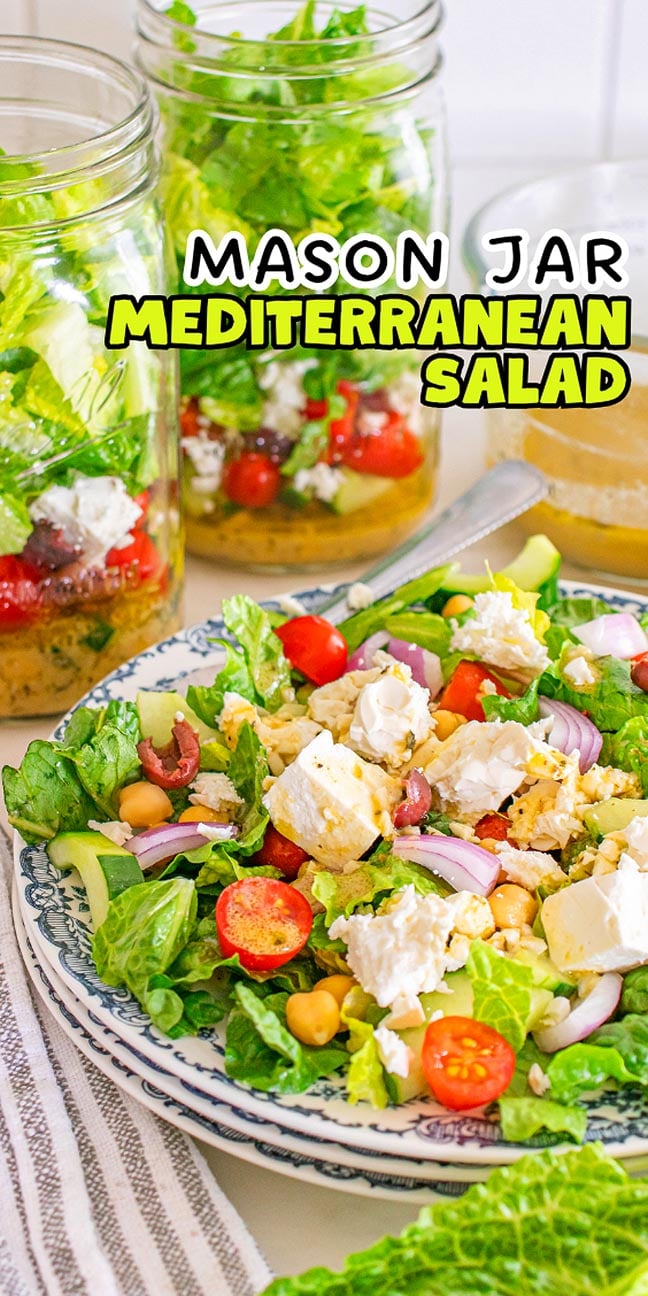 A plate of Mediterranean salad with feta, chickpeas, and veggies sits in front, while Mason Jar Mediterranean Salads are stacked neatly in the background.