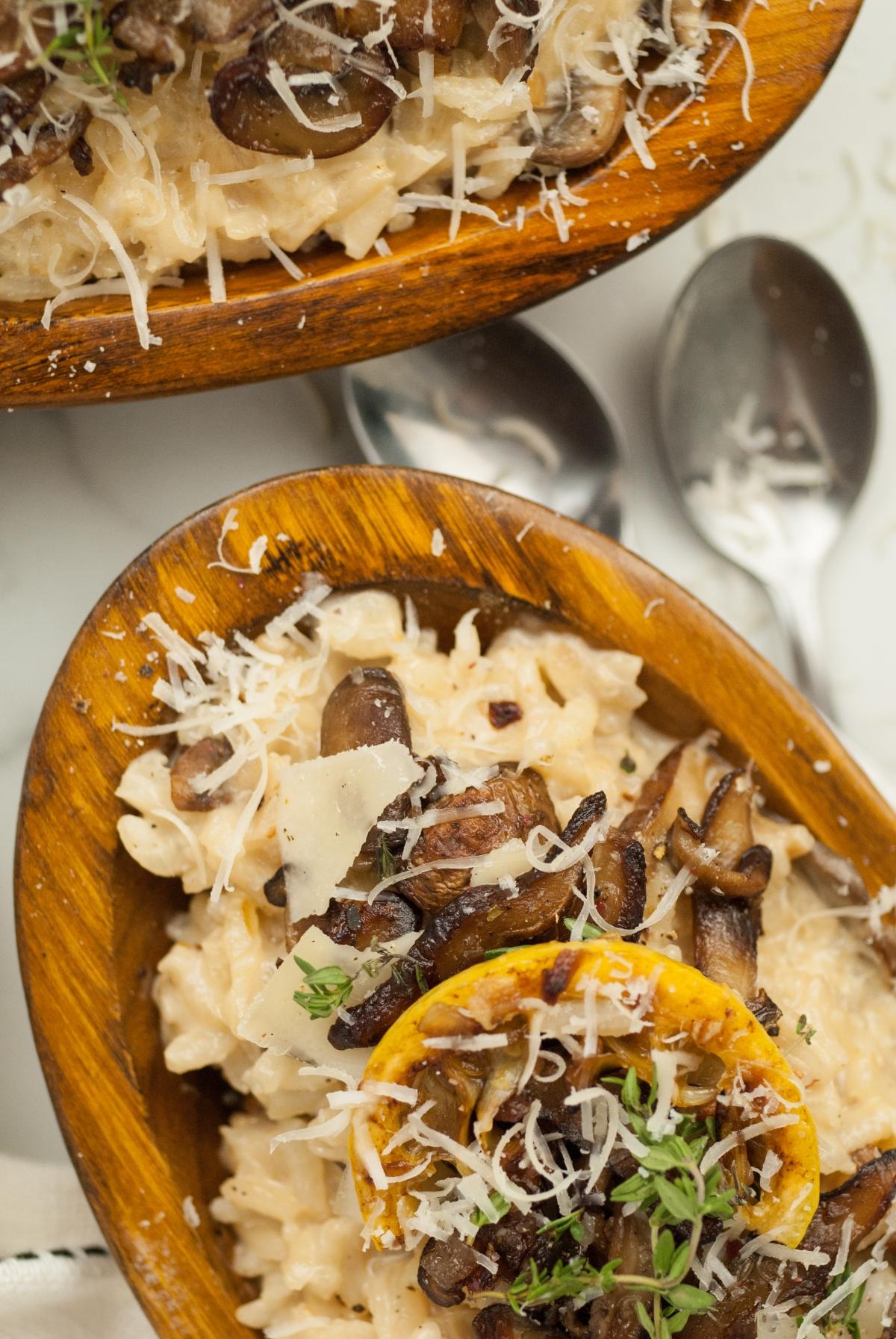 Creamy mushroom risotto topped with grated cheese and herbs, served in wooden bowls with spoons nearby—perfect as a side dish for chicken or turkey or paired with a glass of white wine or Chardonnay.