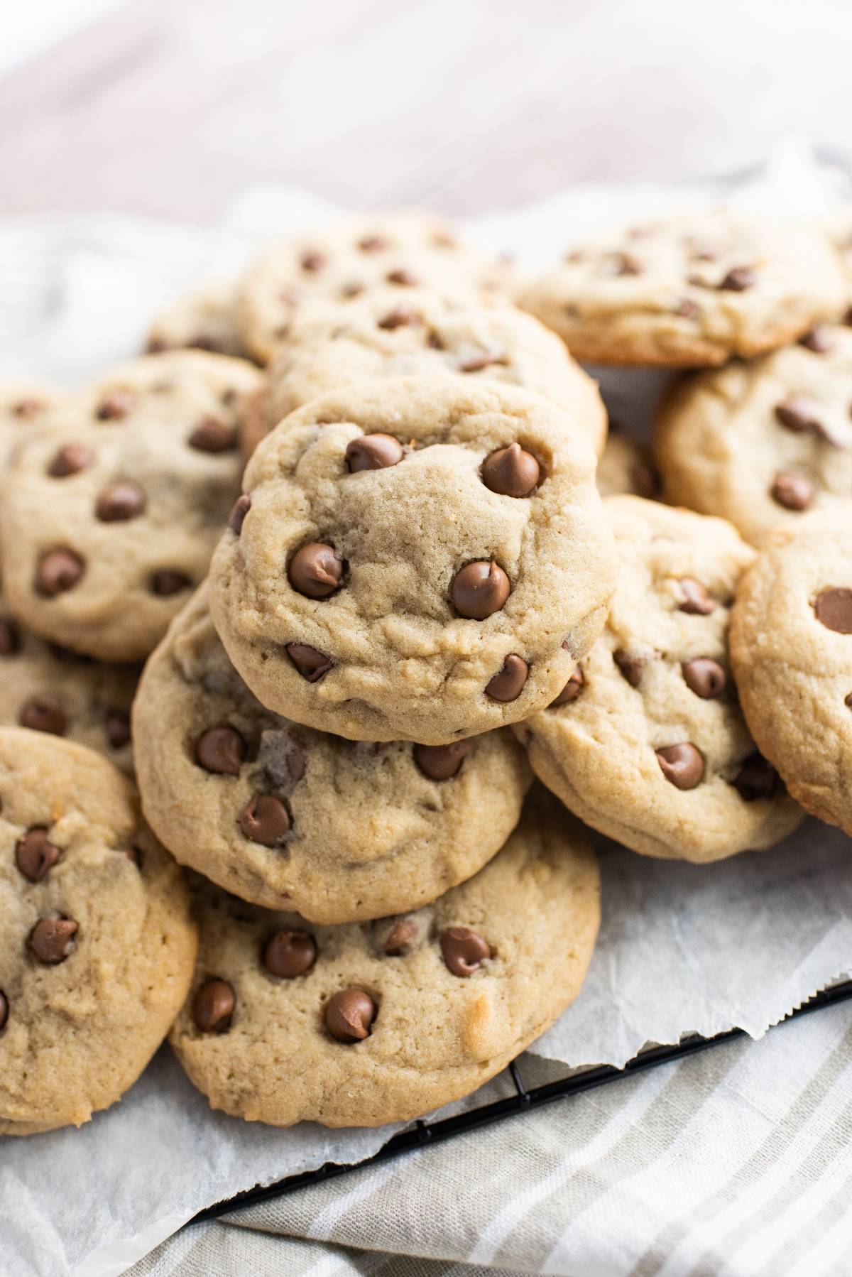 A pile of peanut butter cup stuffed cookies stacked on parchment paper, perfect for using leftover Halloween treats.
