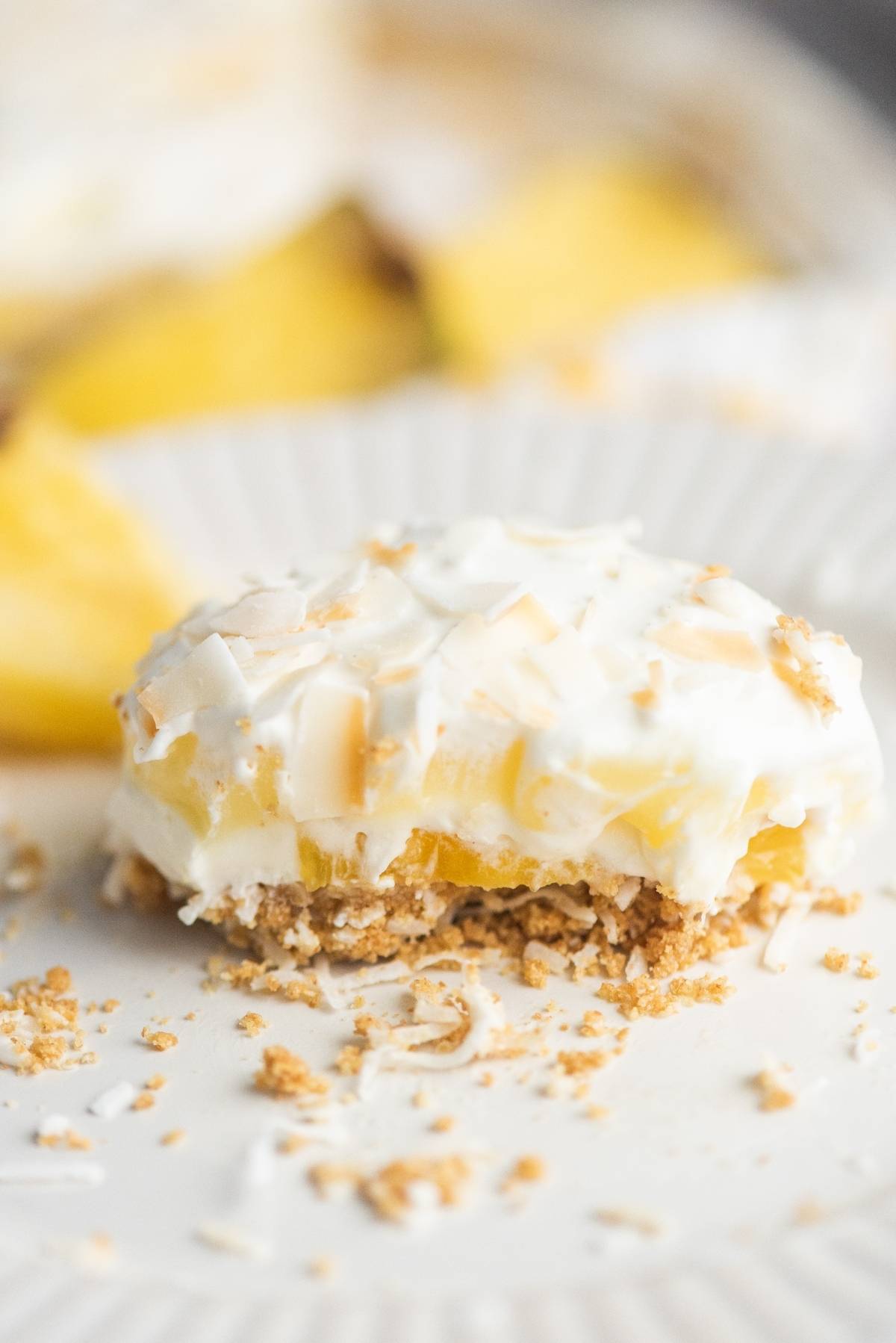 A creamy summer dessert with a crumbly crust and pineapple filling, pineapple lush is topped with whipped cream and toasted coconut—perfect as a dessert for a summer BBQ.