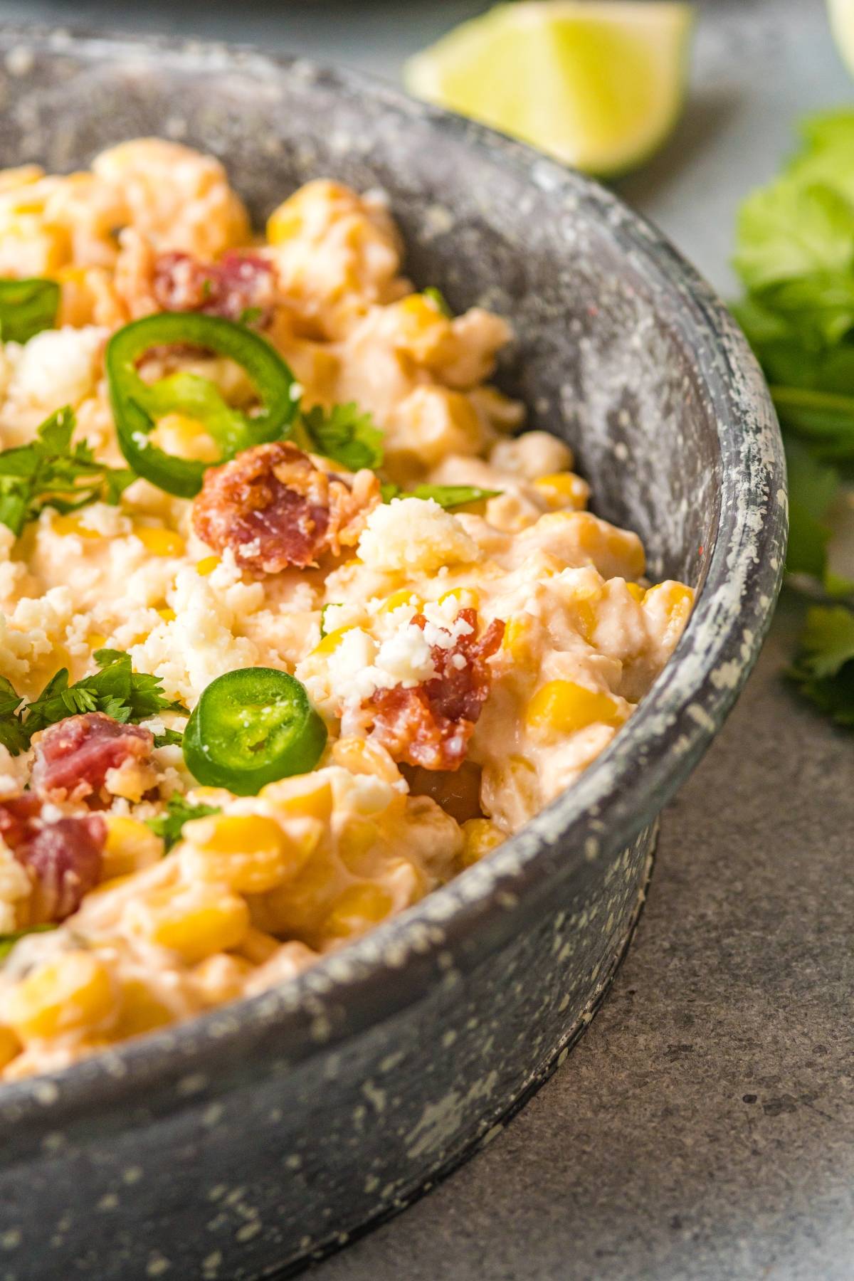 Creamy corn salad with sliced jalapeños, crumbled cheese, cilantro, and sausage in a rustic bowl—perfect as a hearty jalapeño corn dip or served warm as a slow cooker dip recipe for gatherings.