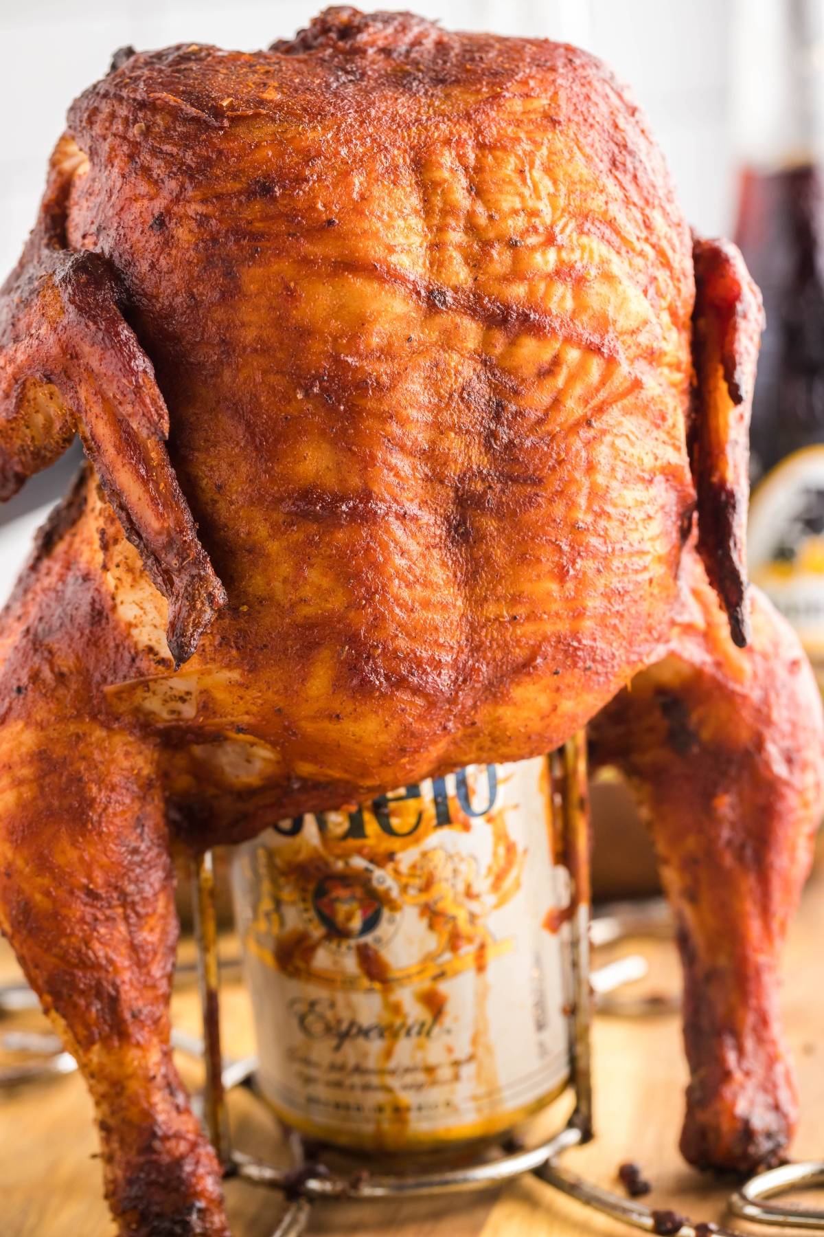 Whole roasted chicken sitting upright on a can of beer, with crispy, seasoned skin—perfect if you want to make beer can chicken or add a twist with Mexican BBQ sauce. A grilled chicken recipe that's sure to impress.