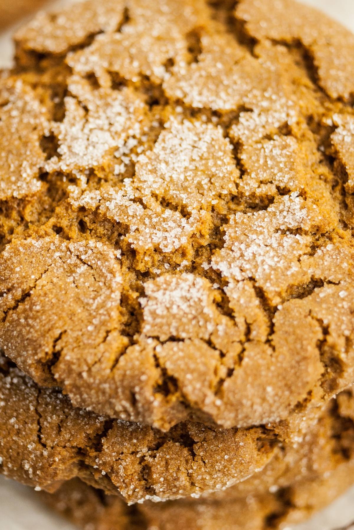 Close-up of stacked ginger cookies topped with granulated sugar, capturing cracked, golden-brown surfaces reminiscent of homemade Starbucks Christmas cookies.